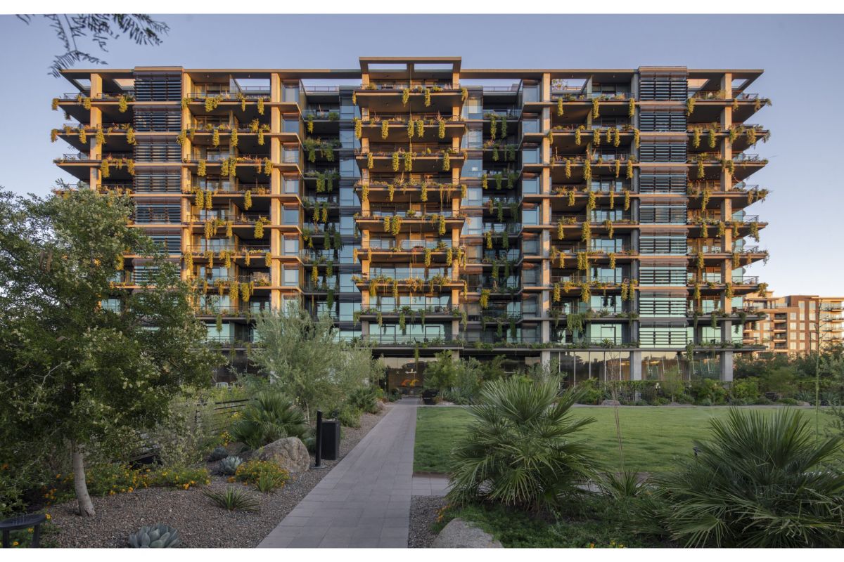 Modern multi-story building with balconies and greenery, ideal for those choosing community within the sought-after Optima Community.