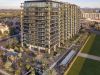 A modern apartment building with glass balconies, featuring vertical landscaping and a rectangular water feature at Optima Kierland.