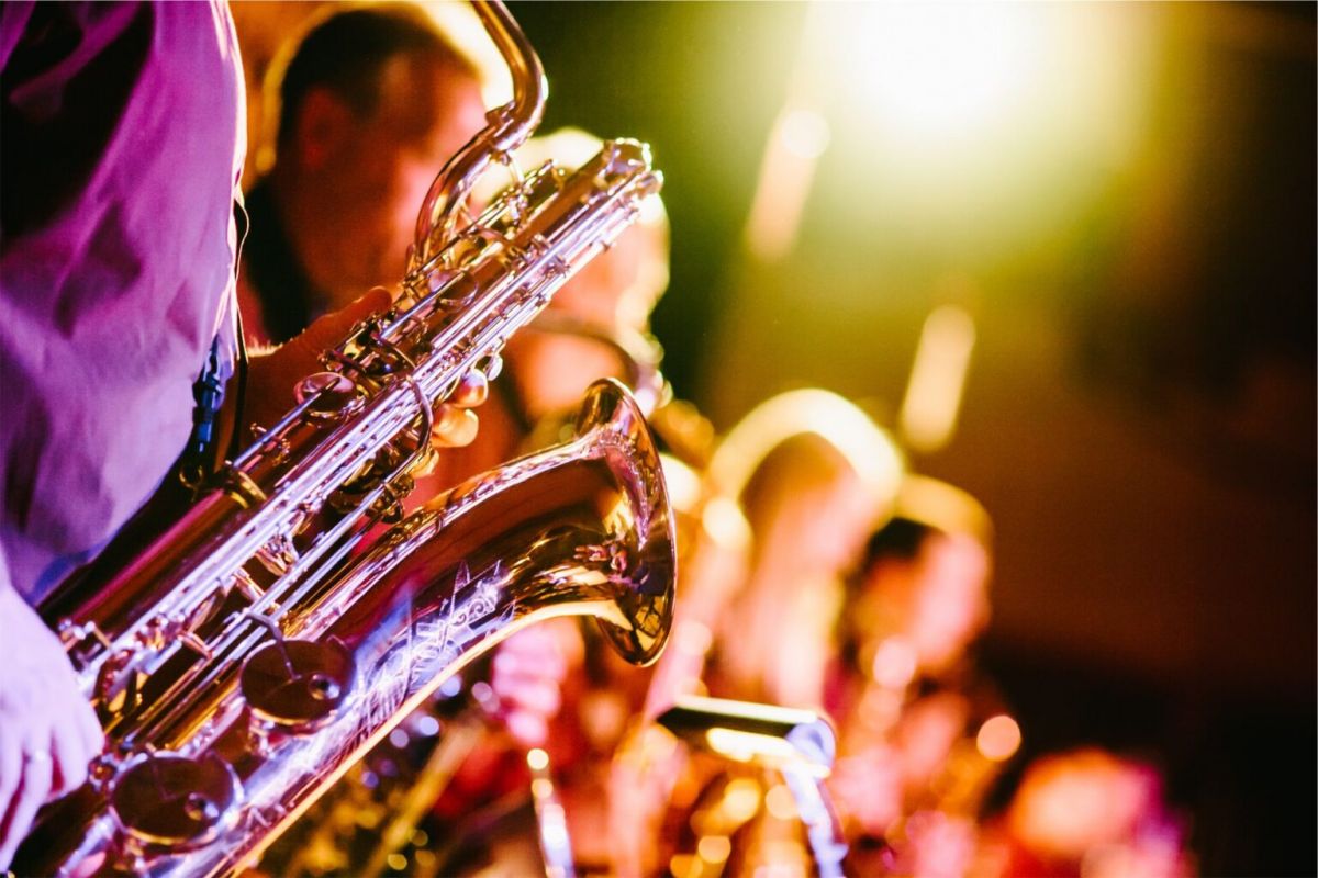 Musicians playing saxophones on stage with bright, colorful lighting at the 2025 Scottsdale Jazz Festival.