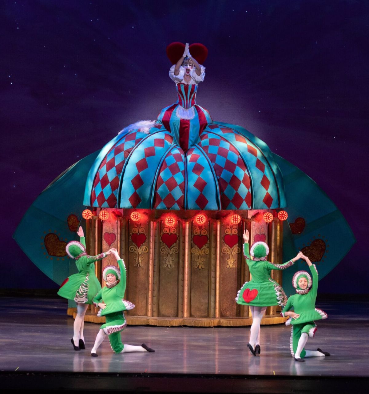 Five ballet dancers in colorful costumes perform on stage before a festive dome prop in Ballet Arizona’s celebrated The Nutcracker.