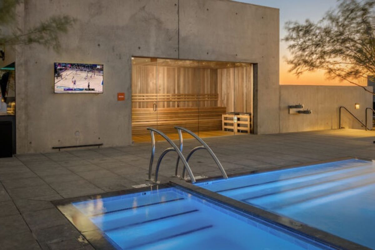 Modern rooftop pool at sunset with a sauna, TV showing basketball, and trees—perfect for relaxing and embracing healthy life longevity trends.