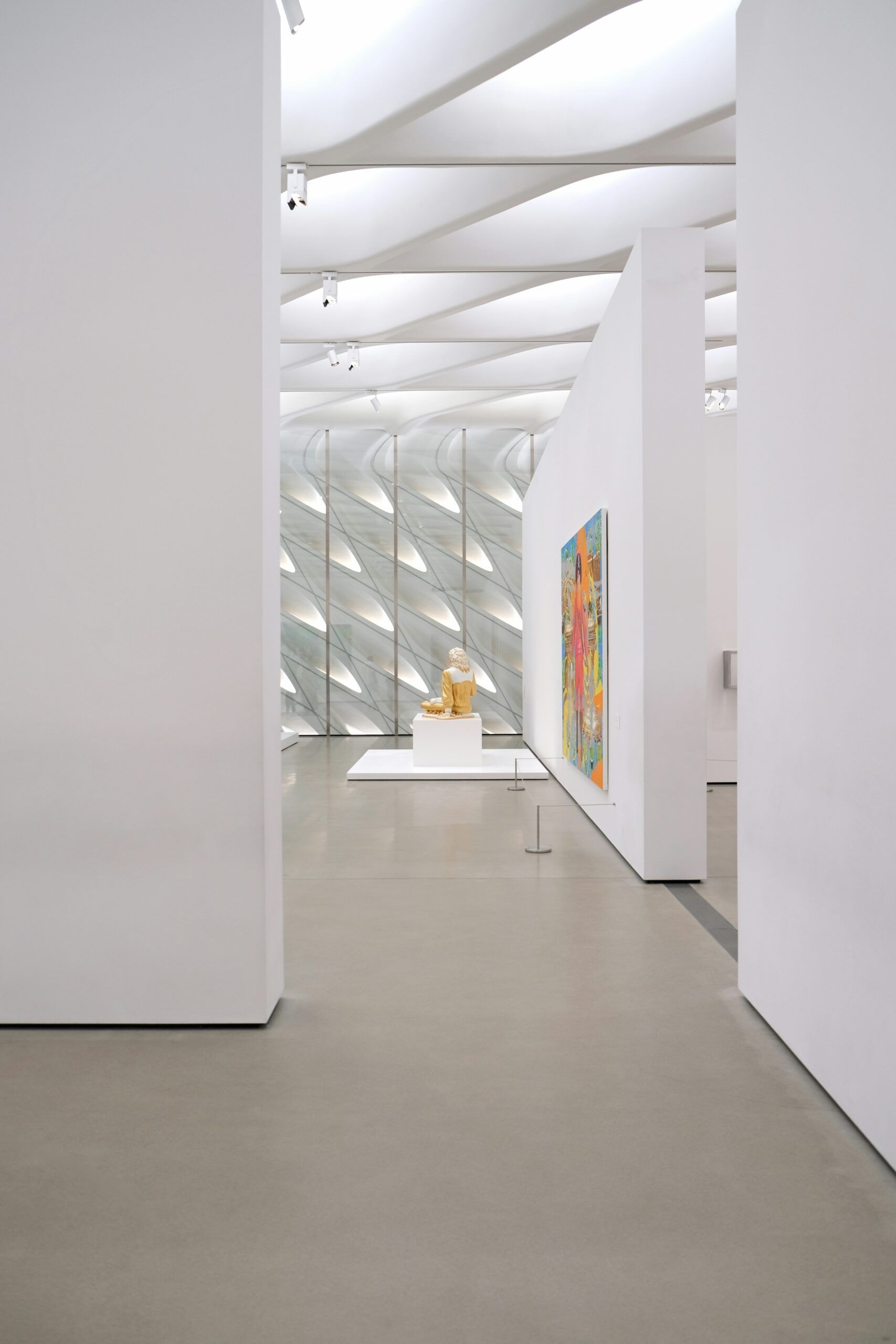 A bartender serves a customer at a stylish bar with a neon "Canal Club" sign and shelves of bottles behind them in Scottsdale, near Optima Sonoran Village apartments.