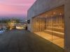 A rooftop sauna at Optima Kierland Apartments overlooks a sunset city, with lounge chairs and potted trees completing the Recovery Circuit.
