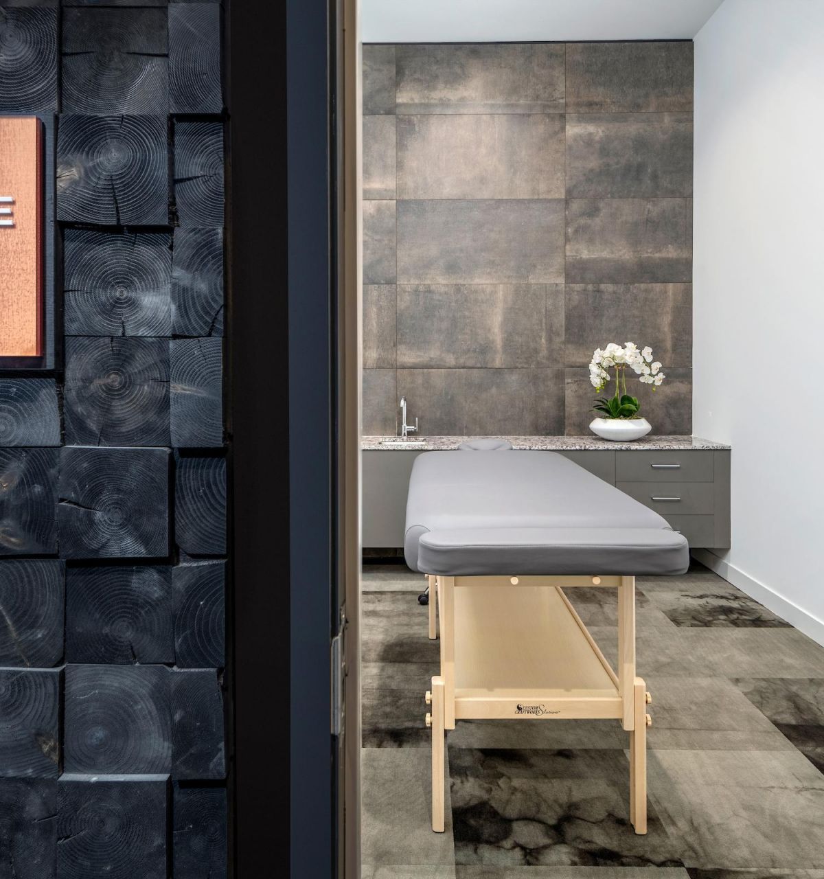 Woman practicing yoga in a modern room with large windows showing a scenic outdoor view at sunset.