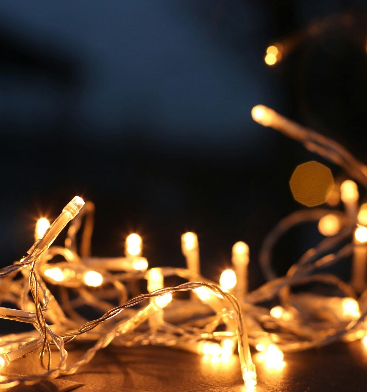 Warm yellow string lights glowing in the dark add cozy charm to home decor, creating a festive and inviting atmosphere.