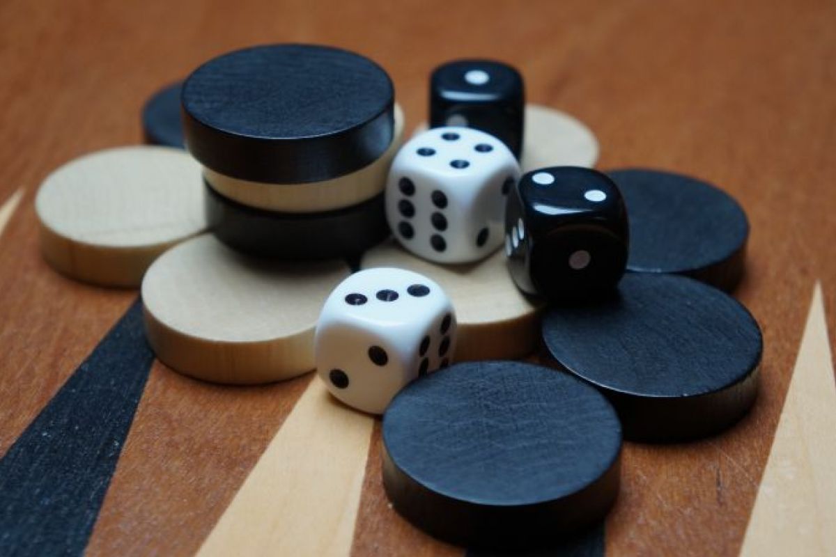 Classic game set: black and white dice and checkers on a wooden backgammon board at Optima Communities.