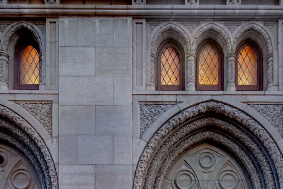 A person enters Phoenix’s Monroe Street Abbey, a hidden gem with arched doorways and warmly lit windows at dusk.