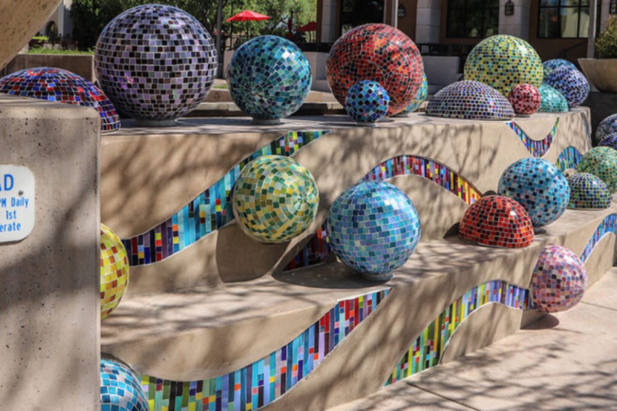 Colorful mosaic tile spheres decorate a multi-level splash pad, a playful nod to Scottsdale Public Art’s vibrant Pinball Wizard installation.