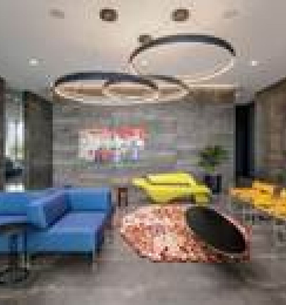 Modern lounge with blue and yellow seating, circular light fixtures, and colorful wall art.