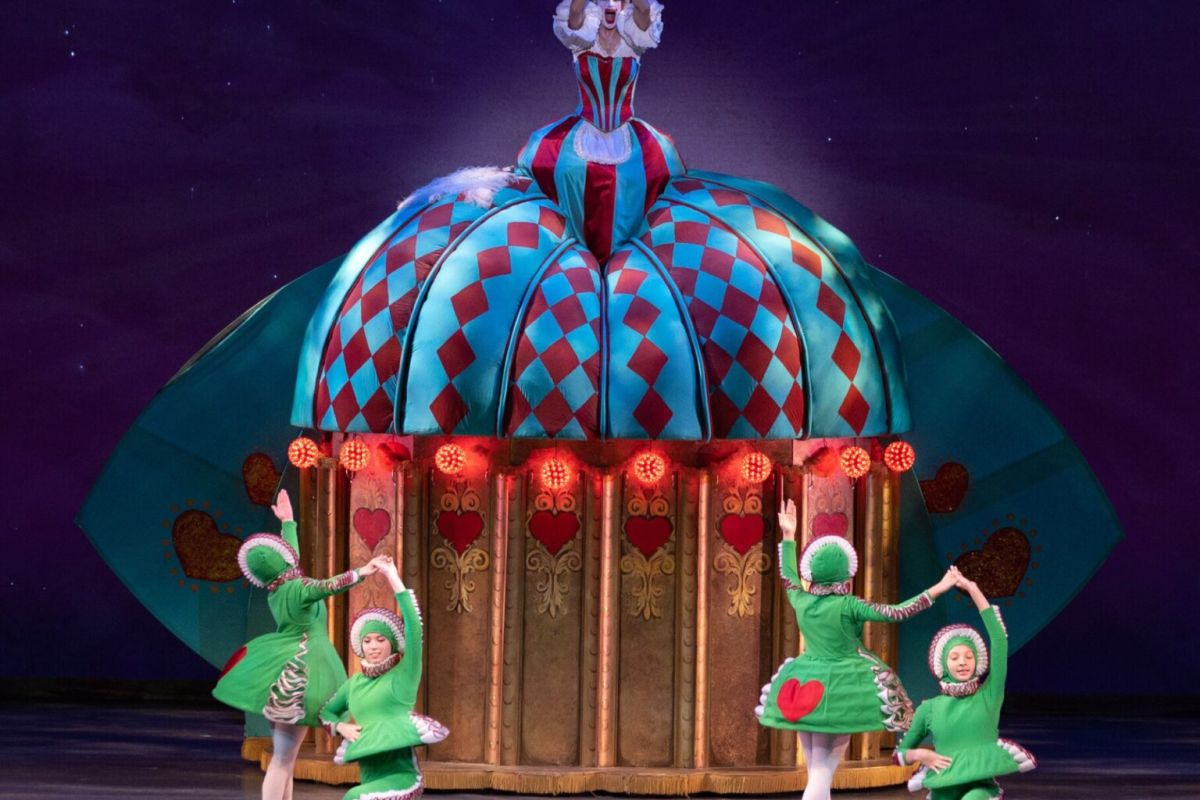 Five ballet dancers in colorful costumes perform on stage before a festive dome prop in Ballet Arizona’s celebrated The Nutcracker.