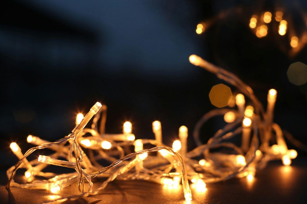 Warm yellow string lights glowing in the dark add cozy charm to home decor, creating a festive and inviting atmosphere.