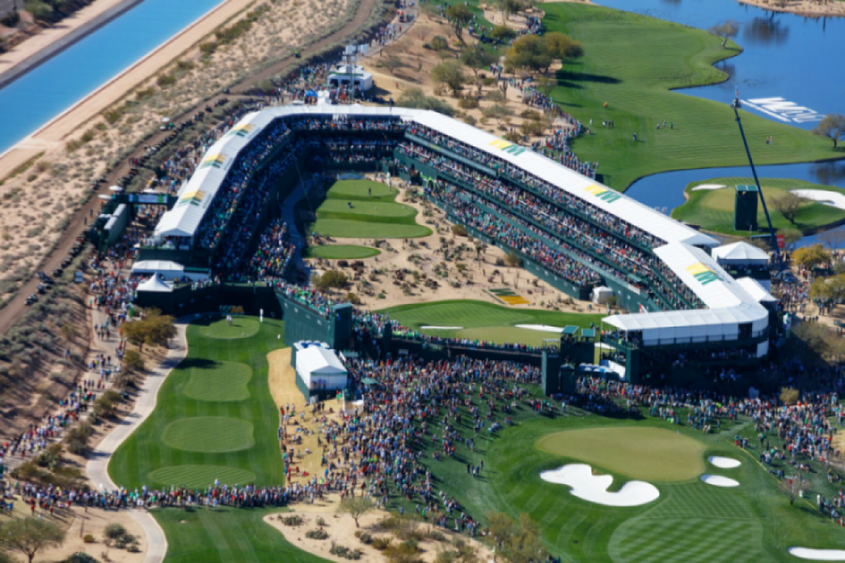 Aerial view of a crowded Phoenix Open golf tournament stadium surrounded by green fairways and sand traps.