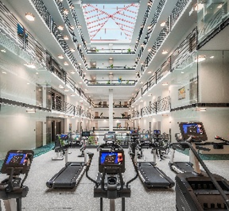 A modern gym with common features like treadmills and exercise equipment, part of the vibrant Optima Portfolio living experience.
